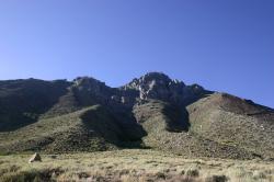 Hills and mountains backed by a blue sky. 